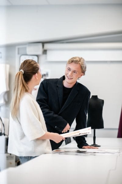 Två elever pratar mode i klassrummet