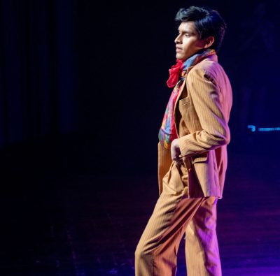 Elev i beige, sydd kostym på catwalk.