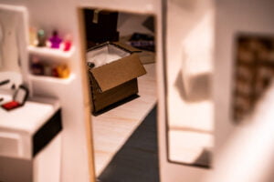 Miniatyr av ett rum med en öppen kartong.