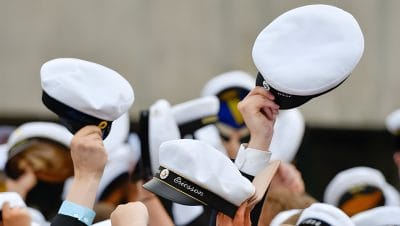 Elever som viftar med studentmössor i luften.