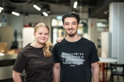 Två elever poserar och ler i skolans lokaler