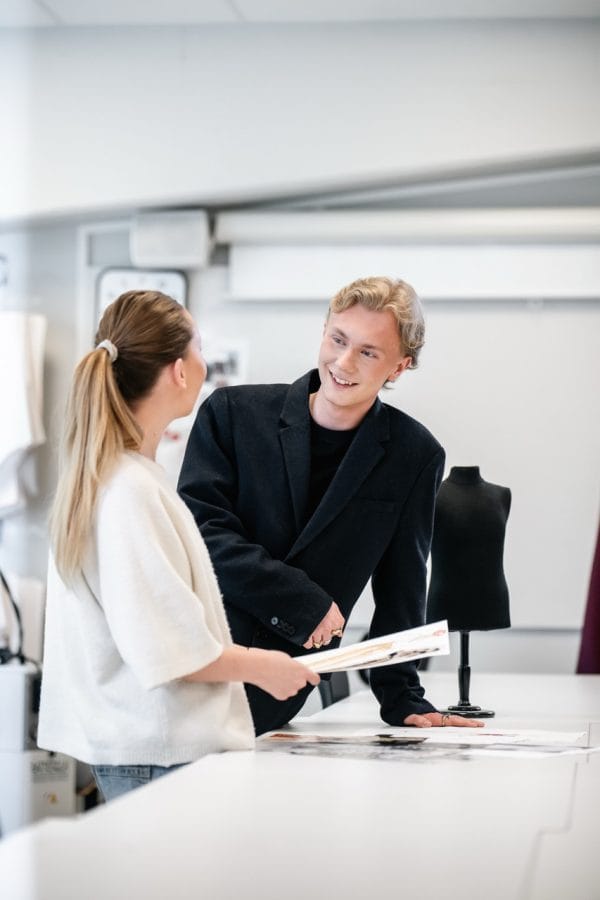 Två elever pratar mode i klassrummet