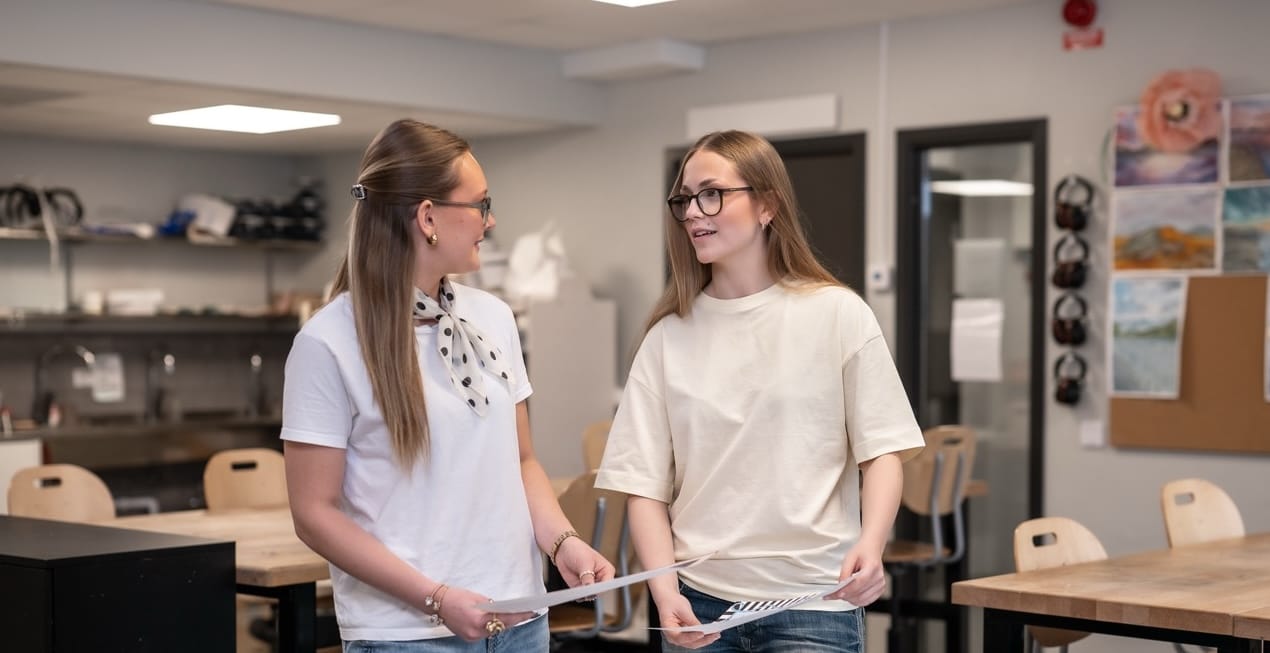 Två elever diskuterar i klassrummet
