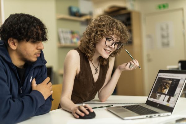Två elever tittar på ritningar på en datorskärm under en lektion.