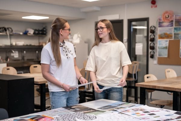 Två elever diskuterar i klassrum